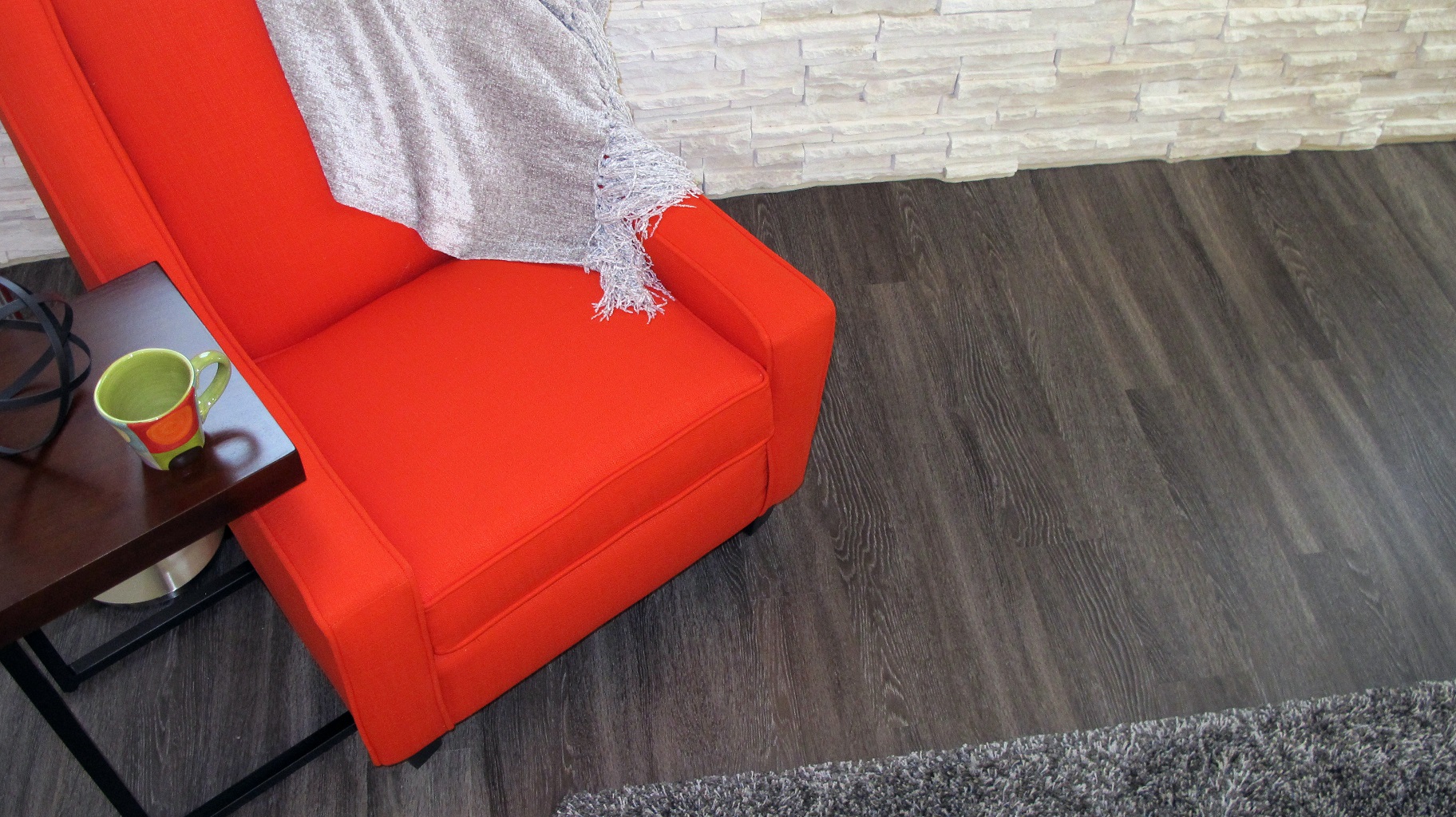 Luxury vinyl plank LVP shaw resilient Harwich Raven floating installation stone masonry white orange chair bright area rug